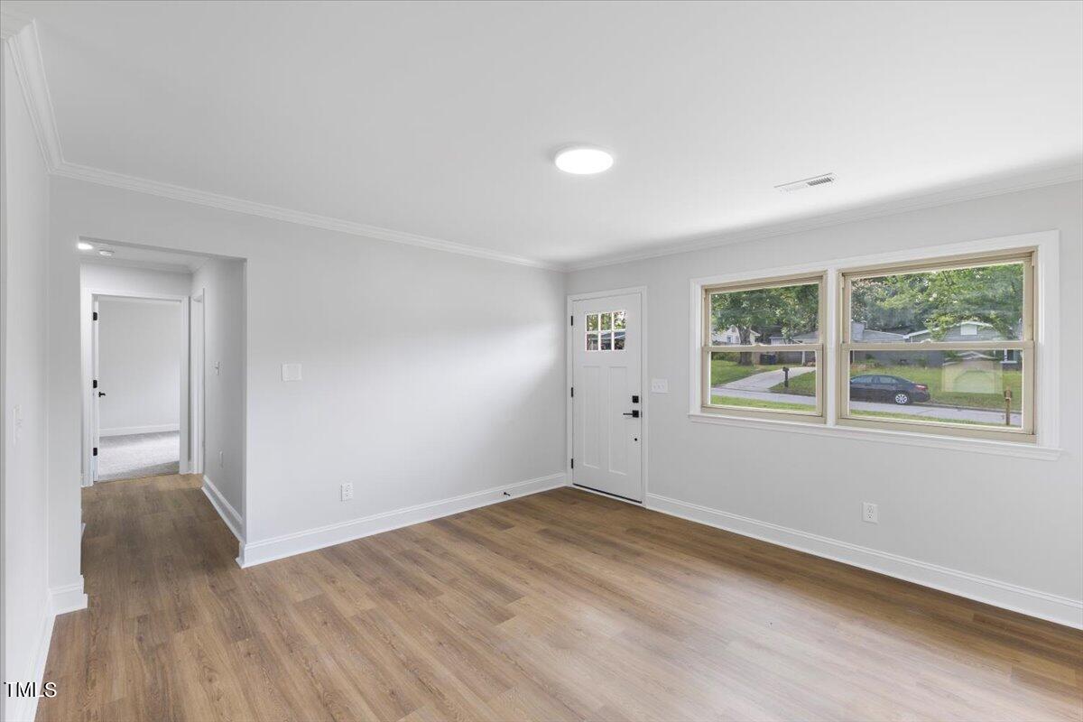 714 Friar Tuck Road Raleigh, NC 27610 - Photo 6 of 25 wooden floor in an empty room with a window