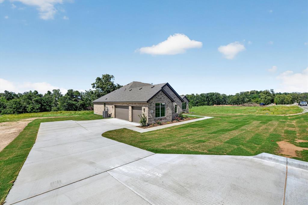 409 Mcalpine Springtown, TX 76082 - Photo 2 of 38 Stone and brick exterior residence with a two-car garage