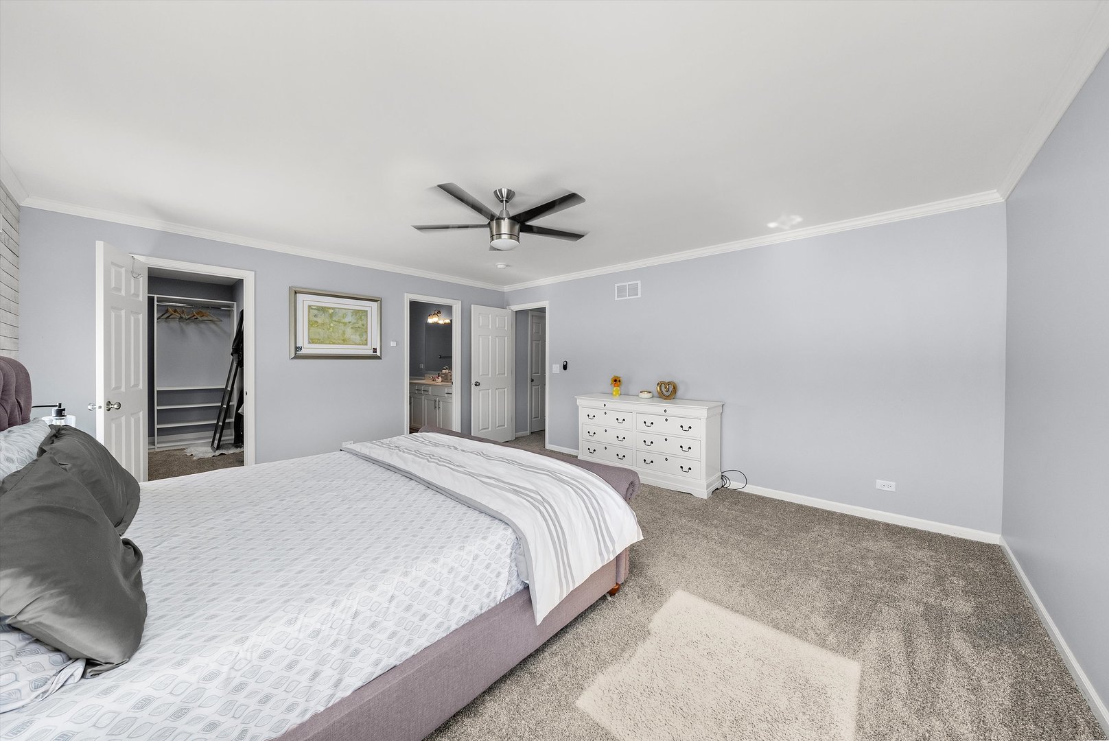 4177 Irving Road Aurora, IL 60504 - Photo 29 of 39 a spacious bedroom with a bed and a chandelier