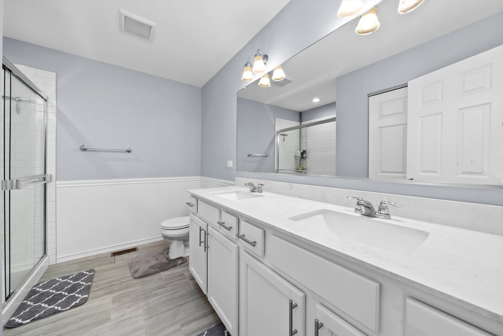 4177 Irving Road Aurora, IL 60504 - Photo 33 of 39 a spacious bathroom with a granite countertop sink a toilet and a mirror