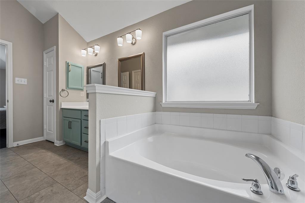 10124 Bunting Drive Waco, TX 76708 - Photo 17 of 18 a white bath tub sitting in a en suite bathroom