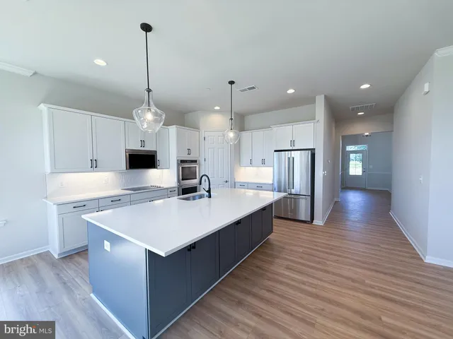 a large kitchen with stainless steel appliances a large kitchen island in the center