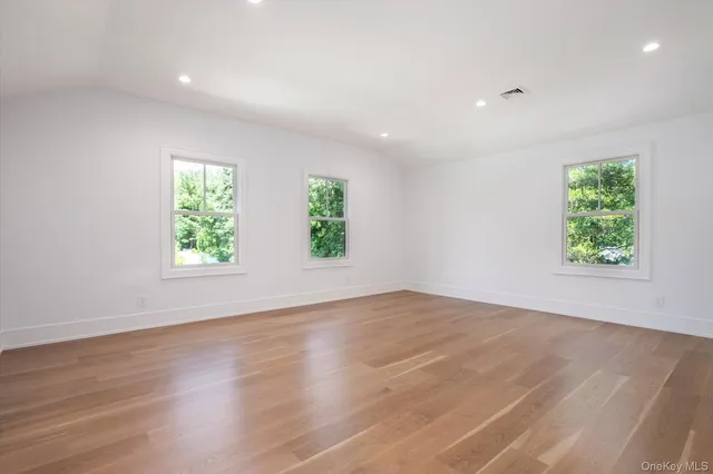 an empty room with wooden floor and window
