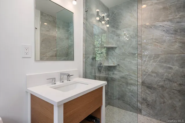 a bathroom with a sink mirror and shower