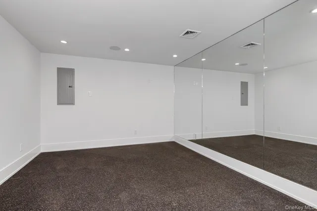 an empty room with wooden floor and natural light