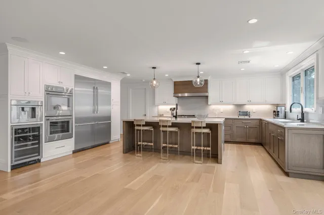 a kitchen with stainless steel appliances kitchen island granite countertop a stove a sink a refrigerator and a island