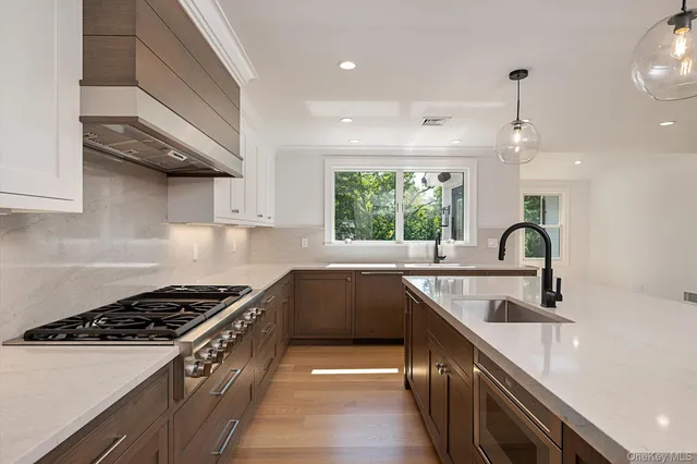 a kitchen with kitchen island a sink stove top oven and cabinets