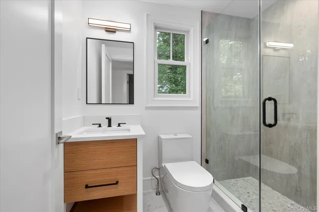 a bathroom with a toilet sink vanity and mirror