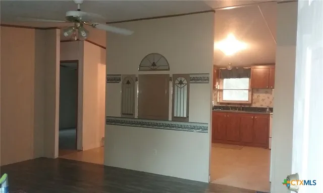a view of a hallway with wooden floor and a cabinet