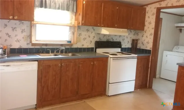 a kitchen with a stove a sink and a refrigerator