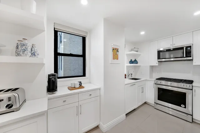 a kitchen with cabinets appliances and a window