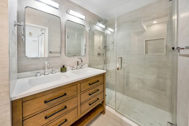a bathroom with a granite countertop sink mirror and shower