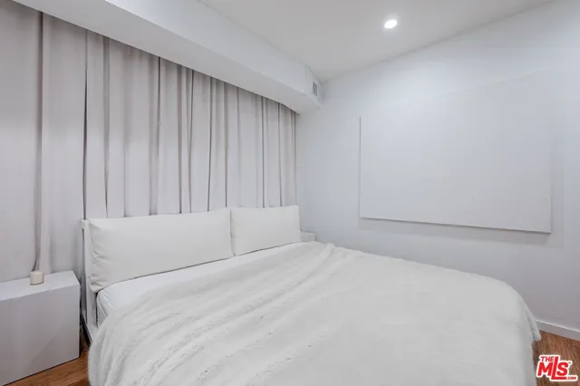 a bedroom with a bed and a wall painting