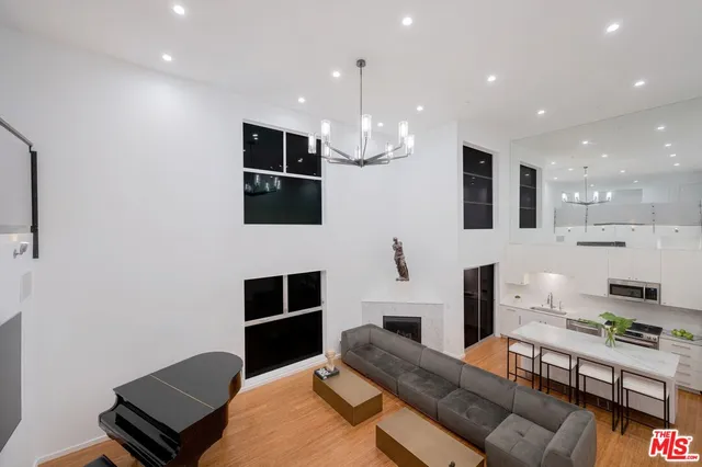 a living room with furniture a flat screen tv and kitchen view