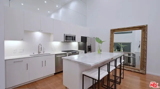 a kitchen with stainless steel appliances a table and chairs in it