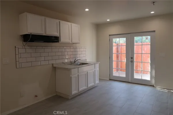 a kitchen with granite countertop white cabinets and white appliances