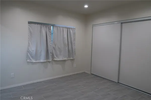 a view of an empty room with wooden floor and cabinet