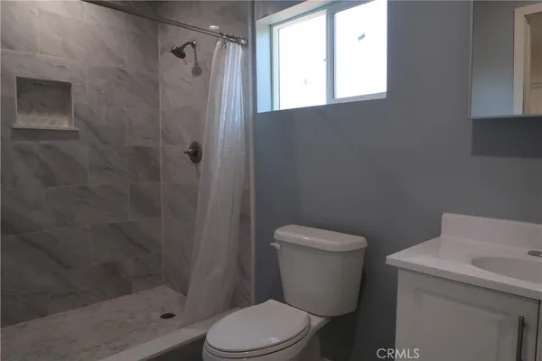 a white toilet sitting next to a shower