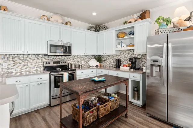 a kitchen with stainless steel appliances granite countertop a stove refrigerator sink and cabinets