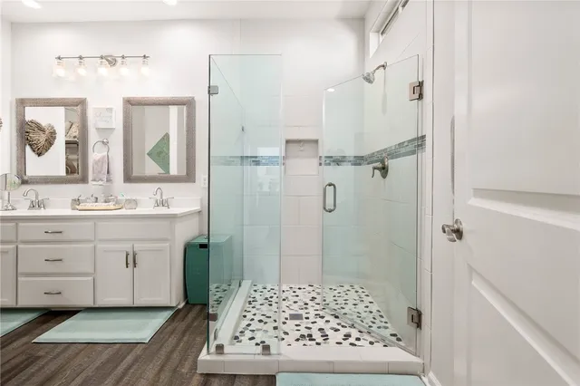 a bathroom with a sink a mirror a vanity and shower