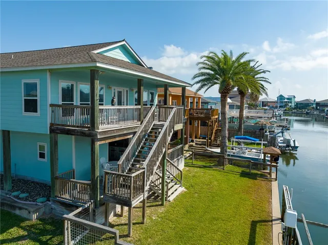 a front view of house with yard slide and large trees