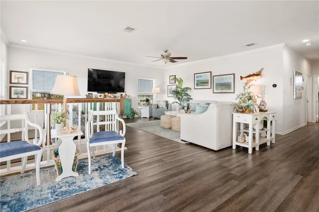 a living room with furniture a flat screen tv and a dining table