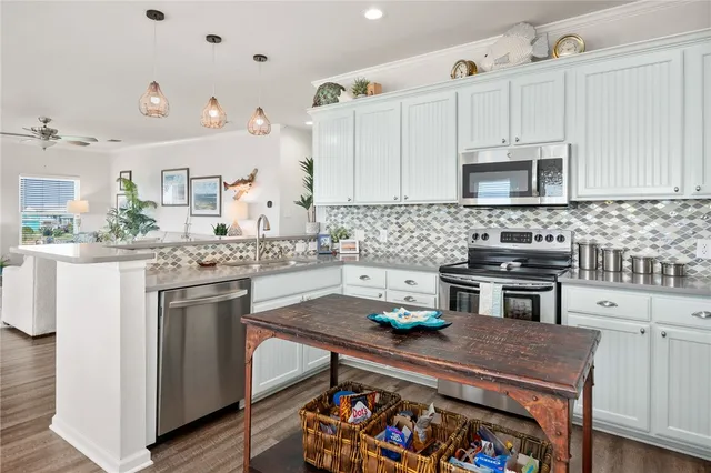 a kitchen with stainless steel appliances granite countertop a stove a sink and a white cabinets