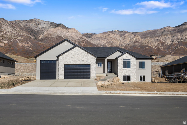 638 East Mountain Road North Ogden, UT 84414 - Photo 2 of 28 View of front facade with stone siding, a mountain view, and an attached garage