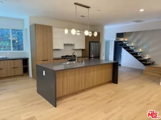 a kitchen with stainless steel appliances granite countertop a sink a stove and a refrigerator