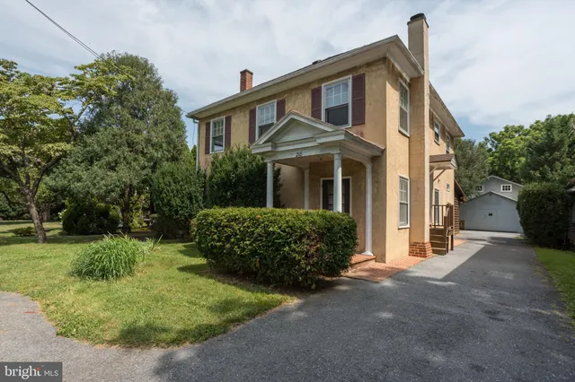 a front view of a house with a yard and trees