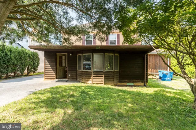 a view of a house with a yard and large tree
