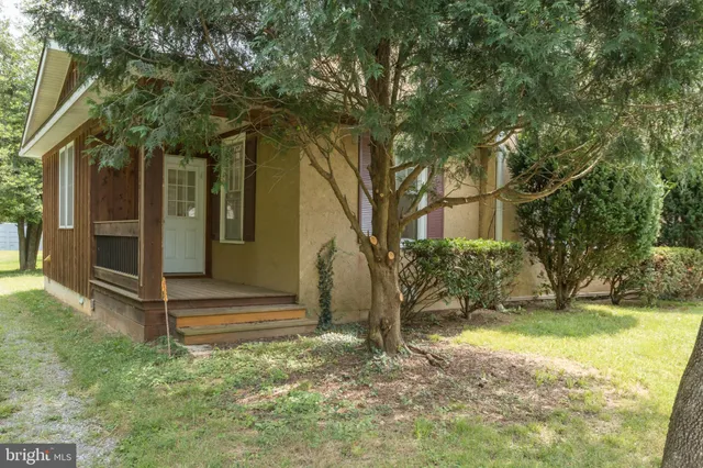 a view of an empty room with wooden floor and closet