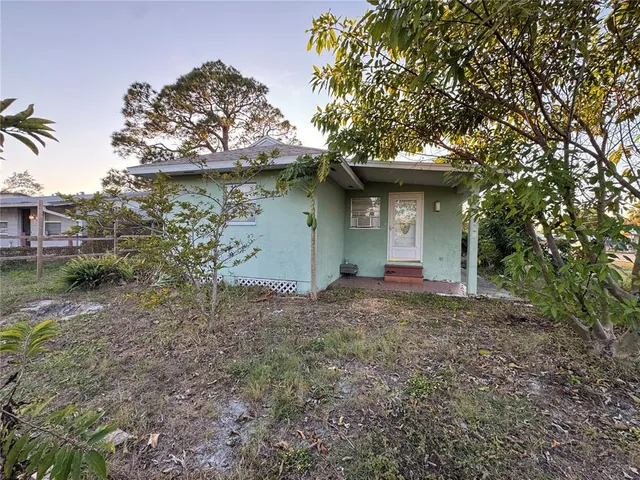 a view of a house with a tree and a yard