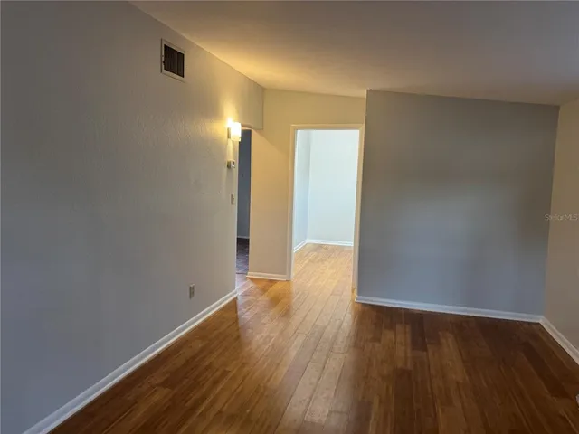 a view of empty room with wooden floor