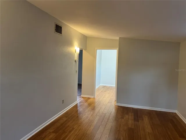 a view of an empty room with wooden floor