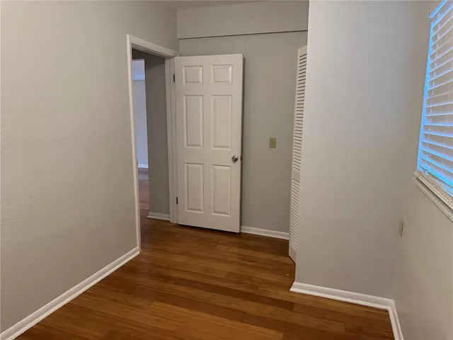 a view of an empty room with wooden floor