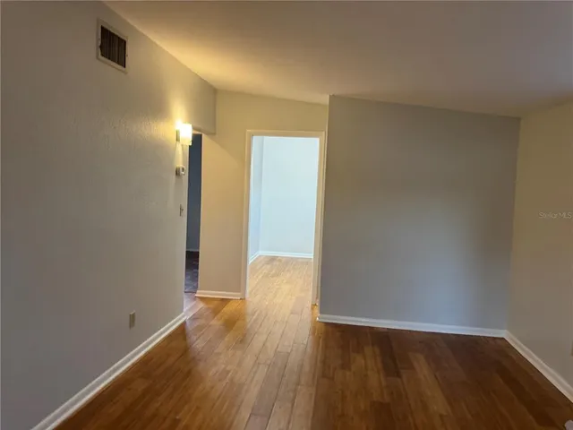 a view of an empty room with wooden floor