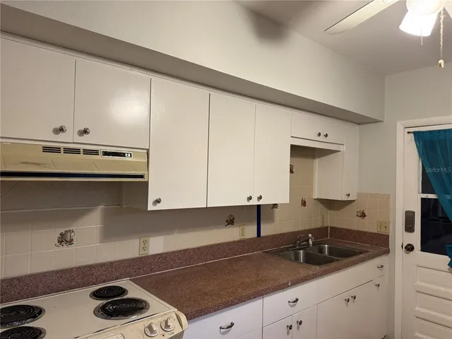 a kitchen with stainless steel appliances a sink stove and cabinets