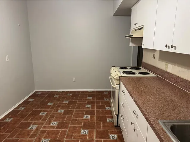 a kitchen with granite countertop a sink and a stove
