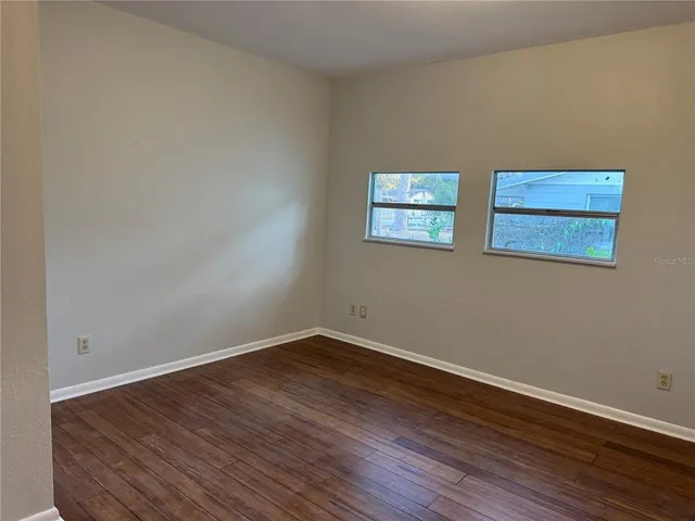 a view of a room with wooden floor and window