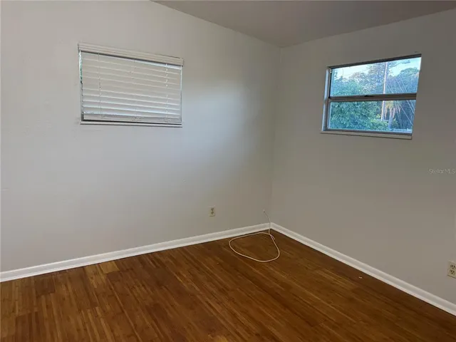 a view of a room with wooden floor and window