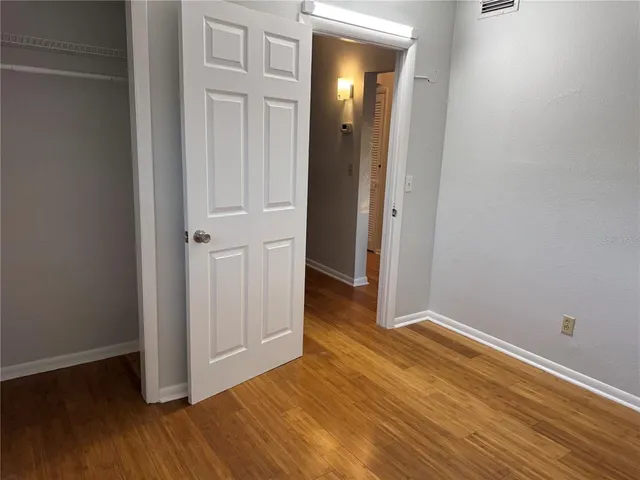 an empty room with wooden floor and closet