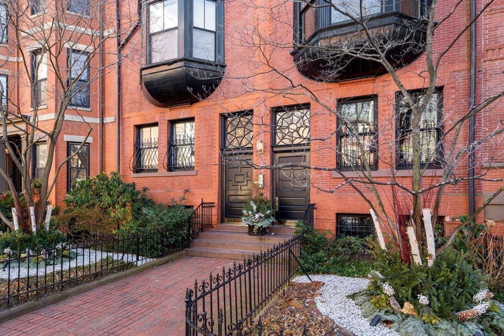 357-359 Beacon Street, Unit 4 Boston, MA 02116 - Photo 9 of 12 a view of a brick house with a large windows and a flower garden