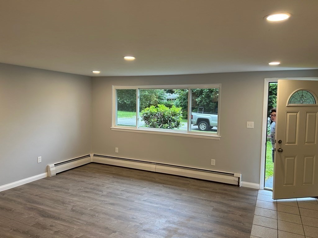 73 Brooks Street Maynard, MA 01754 - Photo 8 of 17 an empty room with wooden floor and a window