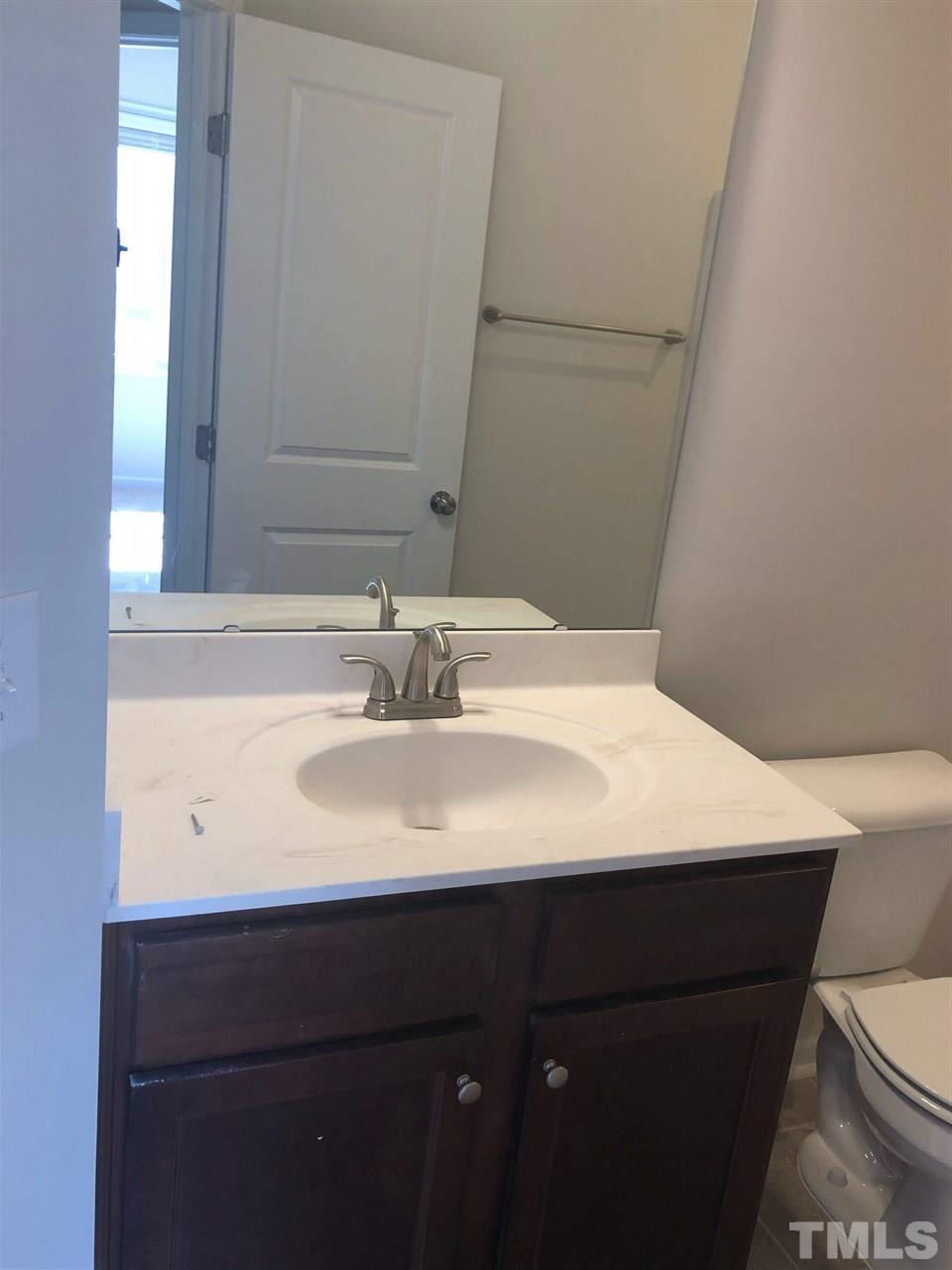 3627 Water Mist Lane, Unit 17 Raleigh, NC 27604 - Photo 14 of 17 a bathroom with a sink a toilet and mirror