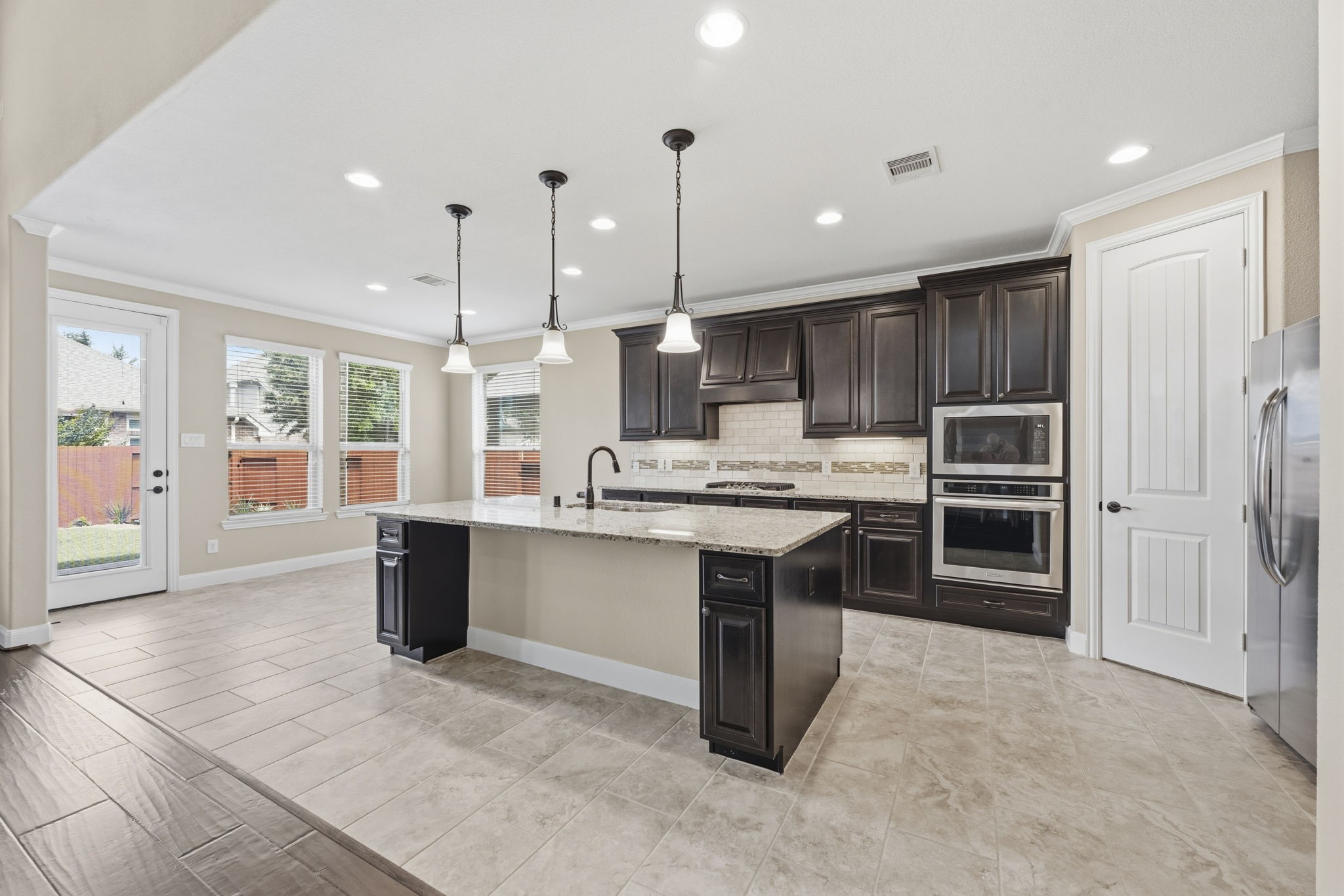 25210 Gaddis Oaks Drive Spring, TX 77389 - Photo 9 of 50 a kitchen with kitchen island a sink stainless steel appliances and cabinets