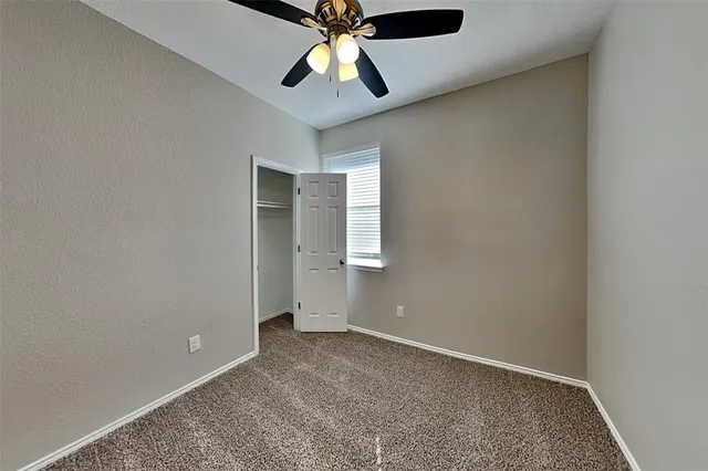 an empty room with chandelier fan