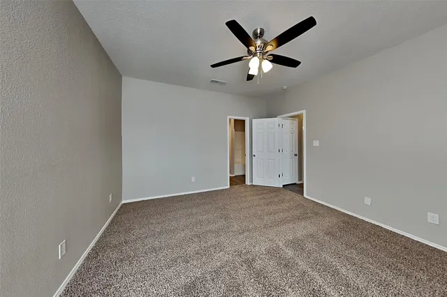 an empty room with closet and windows