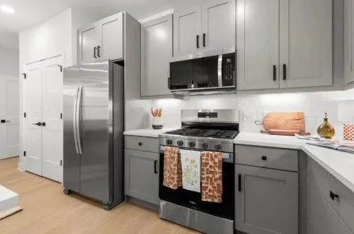 a kitchen with stainless steel appliances a stove a refrigerator a sink a stove and cabinets