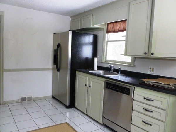 84 Mayflower Road Springfield, MA 01118 - Photo 6 of 14 a kitchen with a sink a refrigerator and cabinets